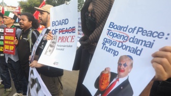 Sejumlah massa membentangkan poster saat mengikuti aksi solidaritas untuk Iran di depan Kedubes Amerika di Jakarta, Selasa (3/3/2026). [Suara.com/Alfian Winanto]