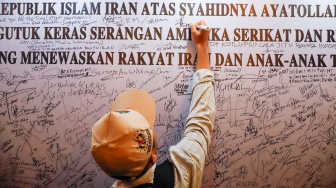 Warga menuliskan pesan dukungan saat Aksi Solidaritas dan Doa Bersama untuk Iran di Kediaman Duta Besar Iran, Jakarta, Kamis (5/3/2026). [Suara.com/Alfian Winanto]