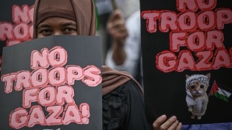 Seorang peserta aksi dari Aliansi Mahasiswa dan Masyarakat Sipil membawa poster saat aksi di depan Gedung DPR RI, Jakarta, Jumat (6/3/2026). [ANTARA FOTO/Fauzan/YU]