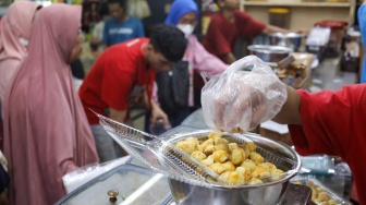 Pedagang melayani pembeli kue kering yang dijual di Pasar Jatinegara, Jakarta, Senin (9/3/2026). [Suara.com/Alfian Winanto]