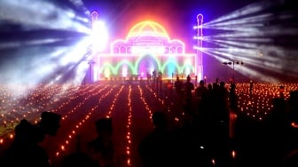 Pengunjung melihat ribuan lampu minyak pada tradisi Tumbilotohe atau malam pasang lampu di Ayula, Kabupaten Bone Bolango, Gorontalo, Senin (16/3/2026). [ANTARA FOTO/Adiwinata Solihin/sgd]