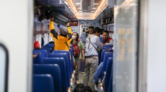 Penumpang memasuki gerbong kereta api di Stasiun Pasar Senen, Jakarta, Selasa (17/3/2026). [Suara.com/Alfian Winanto]