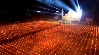 Pengunjung melihat ribuan lampu minyak pada tradisi Tumbilotohe atau malam pasang lampu di Ayula, Kabupaten Bone Bolango, Gorontalo, Senin (16/3/2026). [ANTARA FOTO/Adiwinata Solihin/sgd]