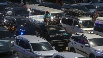 Pemudik duduk di atas kendaraannya saat antre memasuki kapal di Pelabuhan Merak, Kota Cilegon, Banten, Rabu (18/3/2026). [ANTARA FOTO/Angga Budhiyanto/foc]
