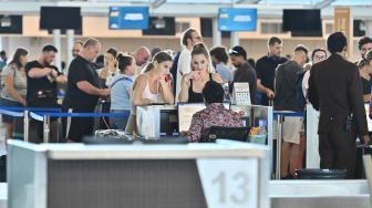 Penumpang pesawat antre di tempat lapor diri Terminal Keberangkatan Internasional Bandara Internasional I Gusti Ngurah Rai, Badung, Bali, Rabu (18/3/2026). [ANTARA FOTO/Fikri Yusuf/agr]
