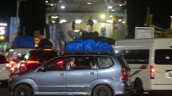 Pemudik duduk di atas sebuah mobil yang melintas memasuki kapal di Pelabuhan Merak, Kota Cilegon, Banten, Rabu (18/3/2026). [ANTARA FOTO/Angga Budhiyanto/foc]
 