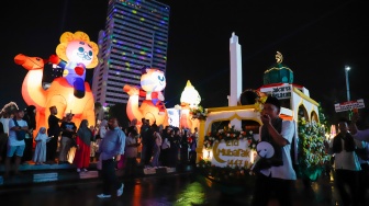 Sejumlah warga menyaksikan pawai obor dan fetival bedug dalam rangka menyambut Hari Raya Idul Fitri 1447 Hijriah di Bundaran HI, Jakarta, Jumat (20/3/2026). [Suara.com/Alfian Winanto]
 