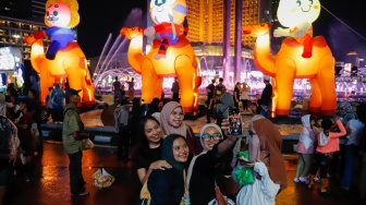 Sejumlah warga menyaksikan pawai obor dan fetival bedug dalam rangka menyambut Hari Raya Idul Fitri 1447 Hijriah di Bundaran HI, Jakarta, Jumat (20/3/2026). [Suara.com/Alfian Winanto]
 