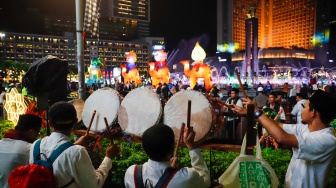 Sejumlah warga menyaksikan pawai obor dan fetival bedug dalam rangka menyambut Hari Raya Idul Fitri 1447 Hijriah di Bundaran HI, Jakarta, Jumat (20/3/2026). [Suara.com/Alfian Winanto]
 