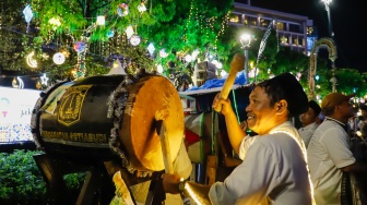 Sejumlah warga menyaksikan pawai obor dan fetival bedug dalam rangka menyambut Hari Raya Idul Fitri 1447 Hijriah di Bundaran HI, Jakarta, Jumat (20/3/2026). [Suara.com/Alfian Winanto]
 