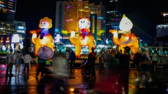 Sejumlah warga menyaksikan pawai obor dan fetival bedug dalam rangka menyambut Hari Raya Idul Fitri 1447 Hijriah di Bundaran HI, Jakarta, Jumat (20/3/2026). [Suara.com/Alfian Winanto]
 