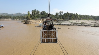 Warga menyeberangi Sungai Peusangan menggunakan kereta gantung kabel baja di Ulee Jalan, Peusangan Selatan, Bireuen, Aceh, Kamis (19/3/2026). [ANTARA FOTO/Irwansyah Putra/wsj]
