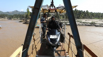 Warga menyeberangi Sungai Peusangan menggunakan kereta gantung kabel baja di Ulee Jalan, Peusangan Selatan, Bireuen, Aceh, Kamis (19/3/2026). [ANTARA FOTO/Irwansyah Putra/wsj]