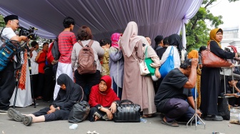 Warga mengantre dan menunggu masuk untuk Halal bihalal bersama Presiden di Istana Negara, Jakarta, Sabtu (21/3/2026). [Suara.com/Alfian Winanto]