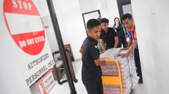Petugas membawa barang bukti yang ditunjukkan seusai konferensi pers di Kantor Kejaksaan Tinggi Kalimantan Timur di Samarinda, Kaltim, Kamis (26/3/2026). [ANTARA FOTO/M Risyal Hidayat/bar]