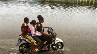 Pengendara motor melintas di jalanan yang tergenang air luapan Danau Sentani di Kalkhote, Asei Besar, Sentani Timur, Kabupaten Jayapura, Papua, Jumat (27/3/2026). [ANTARA FOTO/Gusti Tanati/sgd]