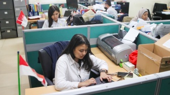 Aparatur Sipil Negara (ASN) menyelesaikan pekerjaan di Balai Kota DKI Jakarta, Rabu (1/4/2026). [Suara.com/Alfian Winanto]