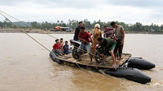 Sejumlah warga menggunakan perahu karet untuk menyeberangi sungai karena jalan utama terputus akibat luapan air sungai di Desa Lhok Cut, Kecamatan Sawang, Aceh Utara, Aceh. Selasa (31/3/2026). [ANTARA FOTO/Rahmad/tom]