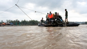 Sejumlah warga menggunakan perahu karet untuk menyeberangi sungai karena jalan utama terputus akibat luapan air sungai di Desa Lhok Cut, Kecamatan Sawang, Aceh Utara, Aceh. Selasa (31/3/2026). [ANTARA FOTO/Rahmad/tom]
