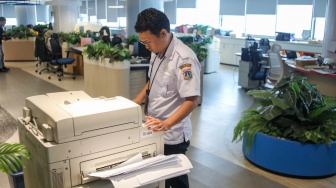 Aparatur Sipil Negara (ASN) menyelesaikan pekerjaan di Balai Kota DKI Jakarta, Rabu (1/4/2026). [Suara.com/Alfian Winanto]