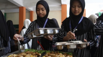 Siswa antre mengambil makanan secara prasmanan dalam uji coba pelaksanaan program Makan Bergizi Gratis (MBG) di MIN 2 Kota Malang, Jawa Timur, Kamis (2/4/2026). [ANTARA FOTO/Ari Bowo Sucipto/rwa]
