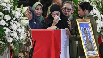 Istri Mayor Inf (Anm) Zulmi Aditya Iskandar (tengah) menangis di atas peti jenazah saat penghormatan jenazah personel penjaga perdamaian yang tergabung dalam United Nations Interim Force in Lebanon (UNIFIL) setibanya di VIP Room Terminal 3 Bandara Soekarno-Hatta, Tangerang, Banten, Sabtu (4/4/2026). [ANTARA FOTO/Fauzan/mrh/YU]