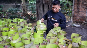 Petugas memindahkan tabung Liquefied Petroleum Gas (LPG) ukuran 3 kg di agen, kawasan Pasar Rebo, Jakarta, Senin (6/4/2026). [Suara.com/Alfian Winanto]

