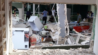 Pekerja merapikan material sisa bangunan rusak yang diduga akibat ledakan tabung gas di area olahraga Loxus Padel, Ciangsana, Gunungputri, Kabupaten Bogor, Jawa Barat, Kamis (9/4/2026). [ANTARA FOTO/Yulius Satria Wijaya/YU]