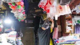 Pedagang melayani pembeli plastik di Pasar Minggu, Jakarta, Kamis (9/4/2026). [Suara.com/Alfian Winanto]
