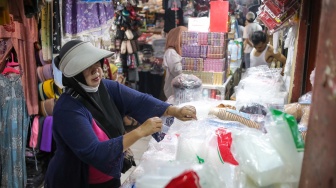 Pedagang melayani pembeli plastik di Pasar Minggu, Jakarta, Kamis (9/4/2026). [Suara.com/Alfian Winanto]
