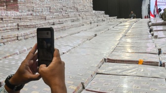 Petugas memotret tumpukan uang dari kegiatan Penyerahan Denda Administratif dan Penyelamatan Keuangan Negara serta Penguasaan Kembali Kawasan Hutan Tahap VI di Gedung Bundar Kejaksaan Agung di Jakarta, Jumat (10/4/2026). [ANTARA FOTO/Fakhri Hermansyah/wsj]