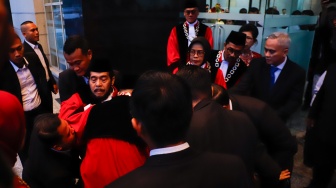 Hakim Konstitusi Anwar Usman (tengah) pingsan saat acara Wisuda Purnabakti dan Penyambutan Hakim di Gedung Mahkamah Konstitusi, Jakarta, Senin (13/4/2026). [Suara.com/Alfian Winanto]