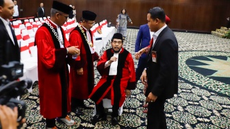 Hakim Konstitusi Anwar Usman duduk beristirahat saat acara Wisuda Purnabakti dan Penyambutan Hakim di Gedung Mahkamah Konstitusi, Jakarta, Senin (13/4/2026). [Suara.com/Alfian Winanto]
