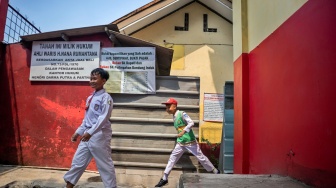 Dua orang murid berjalan di dekat pagar yang dipasang oleh pihak ahli waris di SDN Bunisari, Ngamprah, Kabupaten Bandung Barat, Jawa Barat, Senin (13/4/2026). [ANTARA FOTO/Abdan Syakura/wsj]