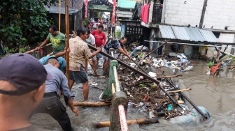 Warga bergotong-royong membersihkan sampah kayu yang terbawa arus banjir di Kampung Gambiran, Kabupaten Sukoharjo, Jawa Tengah, Rabu (15/4/2026). [ANTARAFOTO/Maulana Surya/YU]
