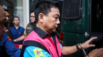 Ketua Ombudsman RI 2026 - 2031 Hery Susanto masuk ke dalam mobil tahanan seusai menjalani pemeriksaan dan penetapan tersangka di Gedung Bundar Jampidsus Kejaksaan Agung, Jakarta, Kamis (16/4/2026). NTARA FOTO/Muhammad Iqbal/agr]