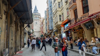 Wisatawan memadati kawasan Galata dengan latar belakang Menara Galata di Kota Istanbul, Turki, Rabu (15/4/2026). [Suara.com/Iramdani]

