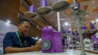 Petugas memeragakan cara penggunaan mesin jahit berteknologi AI dalam pameran Indo Intertex–Inatex 2026 di JIExpo Kemayoran, Jakarta, Kamis (16/4/2026). [Suara.com/Alfian Winanto]