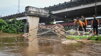 Petugas Unit Penanganan Sampah (UPS) Badan Air Dinas Lingkungan Hidup DKI Jakarta menggunakan jaring untuk menangkap ikan sapu-sapu saat operasi pembersihan di Sungai Ciliwung, Cililitan, Jakarta, Jumat (17/4/2026). ANTARA FOTO/Sulthony Hasanuddin/tom]