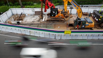 Kendaraan melintas di jalan yang menyempit dampak adanya pengerjaan proyek revitalisasi di Jalan M.H. Thamrin, Jakarta, Senin (20/4/2026). [Suara.com/Alfian Winanto]