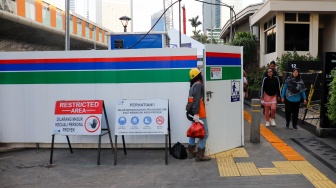 Warga berjalan di pedestrian yang menyempit dampak adanya pengerjaan revitalisasi Stasiun MRT Bundaran HI, Jakarta, Senin (20/4/2026). [Suara.com/Alfian Winanto]