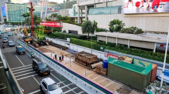 Kendaraan melintas di jalan yang menyempit dampak adanya pengerjaan proyek revitalisasi di Jalan M.H. Thamrin, Jakarta, Senin (20/4/2026). [Suara.com/Alfian Winanto]