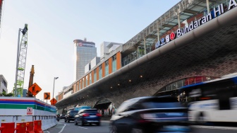Kendaraan melintas di jalan yang menyempit dampak adanya pengerjaan proyek revitalisasi di Jalan M.H. Thamrin, Jakarta, Senin (20/4/2026). [Suara.com/Alfian Winanto]
