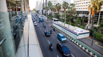 Kendaraan melintas di jalan yang menyempit dampak adanya pengerjaan proyek revitalisasi di Jalan M.H. Thamrin, Jakarta, Senin (20/4/2026). [Suara.com/Alfian Winanto]