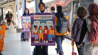Petugas membawa poster kampanye anti kekerasan seksual di Stasiun Sudirman, Jakarta, Selasa (21/4/2026). [Suara.com/Alfian Winanto]
