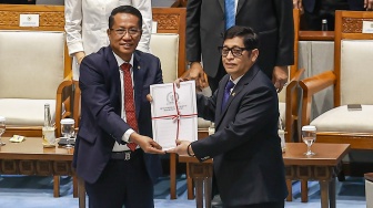 Menteri Hukum Supratman Andi Agtas (kiri) menerima berkas pembahasan dari Ketua Badan Legislasi (Baleg) DPR Bob Hasan (kanan) saat Rapat Paripurna ke-17 Masa Persidangan IV Tahun Sidang 2025-2026 di Kompleks Parlemen, Senayan, Jakarta, Selasa (21/4/2026). [ANTARA FOTO/Dhemas Reviyanto/agr]