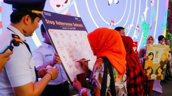Penumpang KRL menandatangani petisi anti kekerasan seksual di Stasiun Sudirman, Jakarta, Selasa (21/4/2026). [Suara.com/Alfian Winanto]
