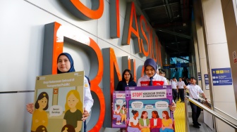 Petugas membawa poster kampanye anti kekerasan seksual di Stasiun BNI City, Jakarta, Selasa (21/4/2026). [Suara.com/Alfian Winanto]
