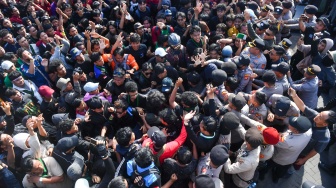 Masa aksi membentangkan poster saat unjuk rasa di depan kantor Gubernur Kalimantan Timur, Samarinda, Kalimantan Timur, Selasa (21/4/2026). [ANTARA FOTO/Angga Palguna/bar]