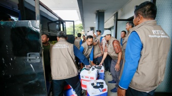 Petugas menyusun koper calon jamaah haji kedalam bus di Asrama Haji Pondok Gede, Jakarta, Selasa (21/4/2026). [Suara.com/Alfian Winanto]
